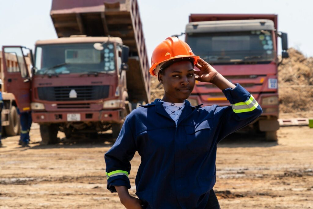 A woman in a hard hat standing in front of trucks